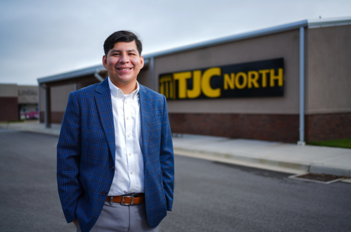 Man wearing a sport coat smiling and standing in front of a TJC North building.